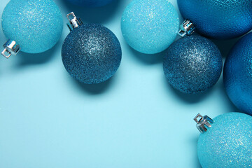 Christmas balls on light blue background, top view. Space for text