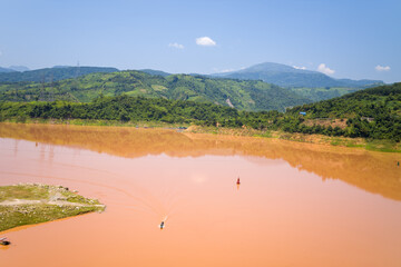 The red river in the middle of the green mountains, in Asia, Vietnam, Tonkin, between Dien Bien Phu and Lai Chau, in summer, on a sunny day.
