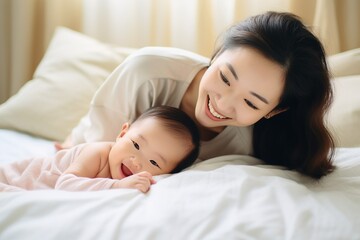 Fototapeta na wymiar family and motherhood concept - happy smiling young asian mother with little baby at home
