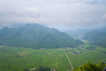 The mountains around the green rice fields in the valley, Asia, Vietnam, Tonkin, towards Hanoi, Mai Chau, in summer, on a sunny day.