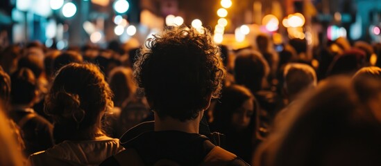 Unidentified crowd seen from behind at nighttime event.