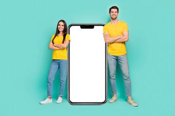 Photo of confident cute married couple wear yellow t-shirts arms crossed modern gadget empty space isolated teal color background - Powered by Adobe