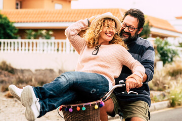 Two happy and active person man and woman enjoying bike ride together having fun and laughing a...