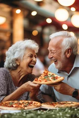 Tuinposter Couple of elderly gentlemen with white hair are smiling while eating a pizza. Celebrating anniversary in pizzeria sitting outdoors. Happy people concept © simona