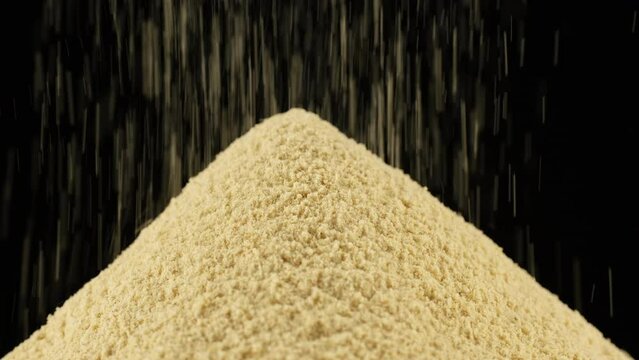 Sprinkle ground ginger powder, isolated on black background. Condiment or dietary supplement