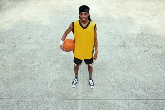 Portrait of determined Black streetball player wearing durag and uniform