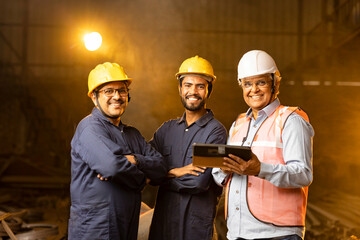 Mechanic with engineer using digital tablet and discussing at factory