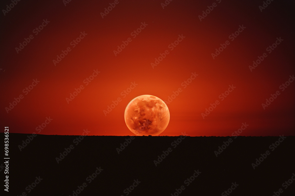 Poster Photograph of a lunar eclipse, showcasing the moon bathed in a reddish glow as Earth's shadow passes over it, creating a celestial spectacle.