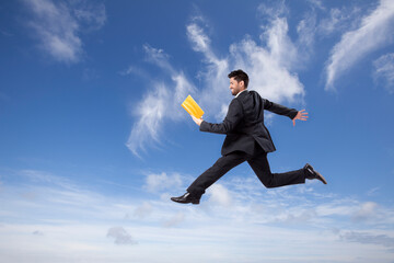 Businessman reading a book while jumping or walking