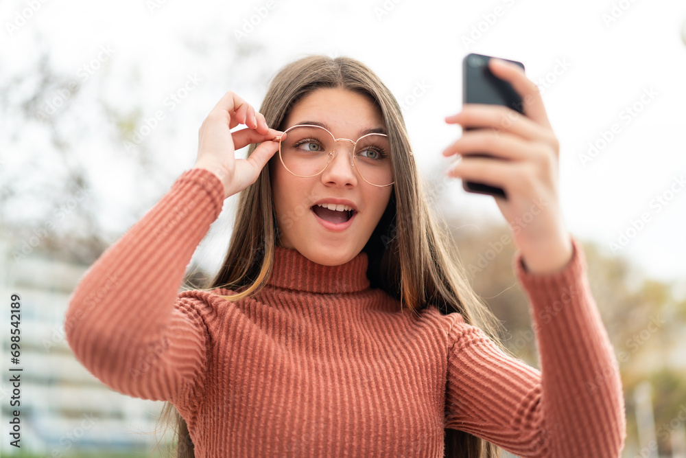 Wall mural Teenager girl at outdoors making a selfie