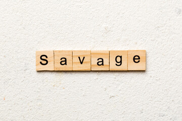 SAVAGE word written on wood block. SAVAGE text on cement table for your desing, concept