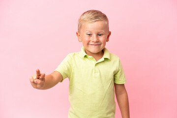 Little Russian boy isolated on pink background smiling and showing victory sign
