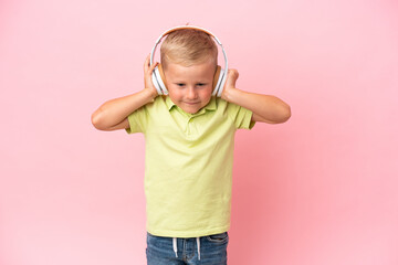 Little Russian boy listening to music with headphones over isolated background