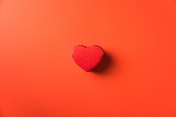 Red heart shaped gift box on red background
