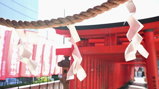 神社の風に揺れる紙垂としめ縄と赤い鳥居