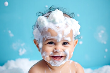 Little smiling baby boy with big soap foam on her head in her hair on a blue background