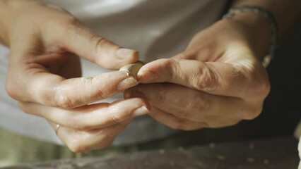 A female potter works on the details of a handmade clay product. Creative leisure and ceramics concept.