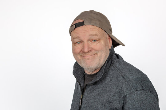 Cheerful Caucasian Middle-aged Man in Backward Baseball Cap on White Background