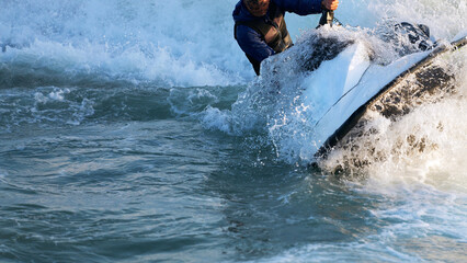 A man on a water scooter at high speed in a plume of splashes and splashing water close-up. Extreme type of active vacation at sea. Copy space. © ROMAN DZIUBALO