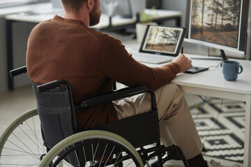 Close up of man with disability working as photo or video editor at office workplace, copy space