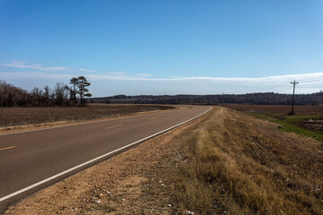 Roadway cutting through open Mississippi farmland - 698572968