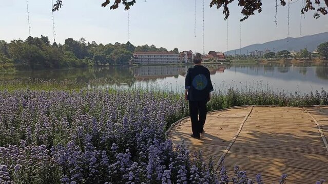 old elderly elder senior woman resting relaxing in flower garden