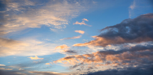 Naklejka na ściany i meble sunset sky background with grey and orange lighted clouds