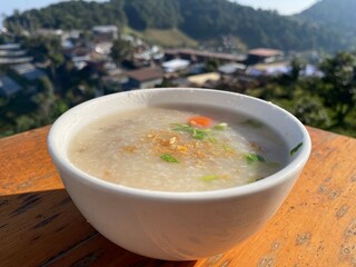 Rice porridge serving in white bowl for breakfast and soft diet concept 