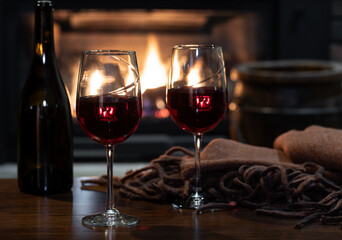 Two glasses of wine with fireplace in background - obrazy, fototapety, plakaty