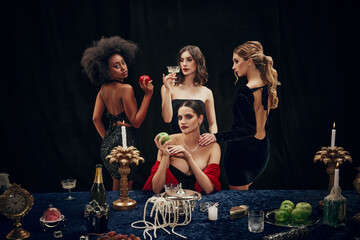Portrait of beautiful, stylish young women, friends in elegant dresses at luxurious restaurant celebrating again dark backwound. Christmas eve. Concept of holidays, upper-class club. Dinner