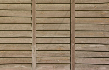 Horizontal texture of a wall from several rows of brown old wooden boards. Painted wooden wall in brown color