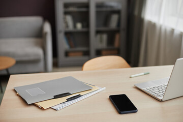 Close up background image of document folders and smartphone on table in home office workplace, copy space