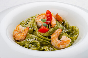 Fettuccini with shrimp and pesto sauce. Isolated image
