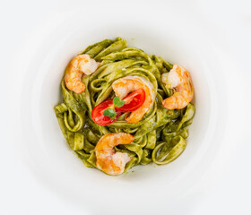 Fettuccini with shrimp and pesto sauce. Isolated image