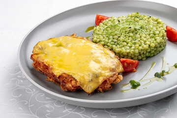 Chicken schnitzel under cheese with pittitimus. Isolated image