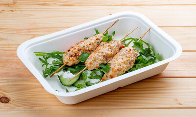 Chicken lula kebab with herbs and vegetables. Healthy food. Takeaway food. On a wooden background.