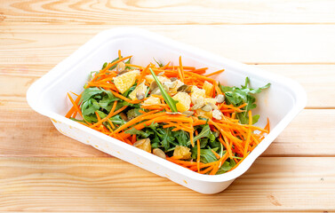 Carrot salad with orange. Healthly food. Takeaway food. On a wooden background.