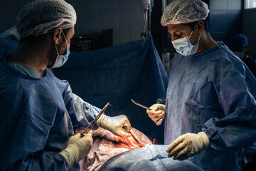 Doctors stitching a patient's back after surgery