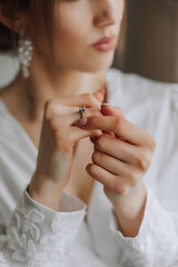 Close-up of an elegant diamond ring on a woman's finger with a modern manicure, sunlight. Love and...