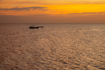 Fisherman and fishing boat in the evening. They are fishing in the middle of the sea in the Gulf of Thailand.
