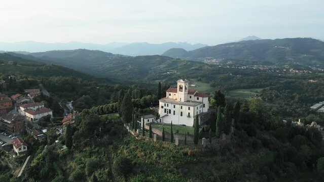 Aerial orbit around cathedral in Montevecchia, Italy named "Santuario della Beata Vergine del Carmelo". Stunning architecture and beautiful forests around. 4K drone shot.