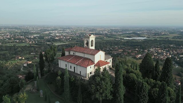Aerial orbit around cathedral in Montevecchia, Italy named "Santuario della Beata Vergine del Carmelo". Stunning architecture and beautiful forests around. 4K drone shot.