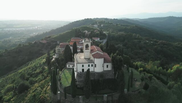 Aerial orbit around cathedral in Montevecchia, Italy named "Santuario della Beata Vergine del Carmelo". Stunning architecture and beautiful forests around. 4K drone shot.