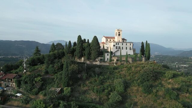 Aerial shot of cathedral in Montevecchia, Italy named "Santuario della Beata Vergine del Carmelo". Stunning architecture and beautiful forests around. 4K drone shot.