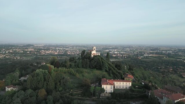 Aerial orbit around cathedral in Montevecchia, Italy named "Santuario della Beata Vergine del Carmelo". Stunning architecture and beautiful forests around. 4K drone shot.