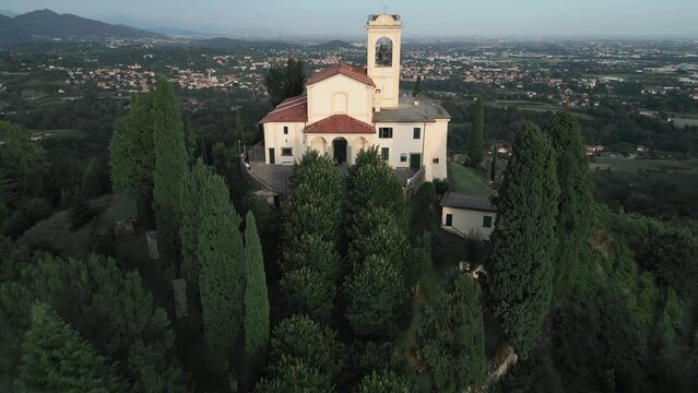 Aerial shot going over cathedral in Montevecchia, Italy named "Santuario della Beata Vergine del Carmelo". Stunning architecture and beautiful forests around. 4K drone shot.