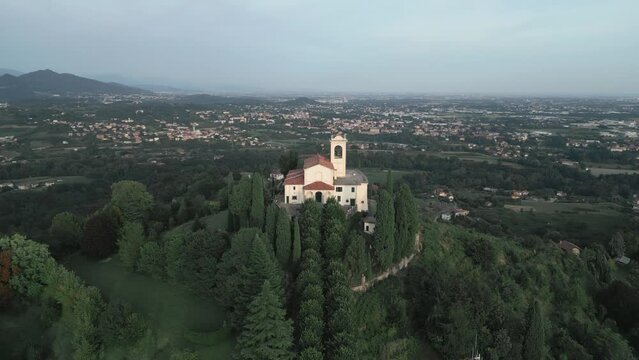 Aerial orbit around cathedral in Montevecchia, Italy named "Santuario della Beata Vergine del Carmelo". Stunning architecture and beautiful forests around. 4K drone shot.