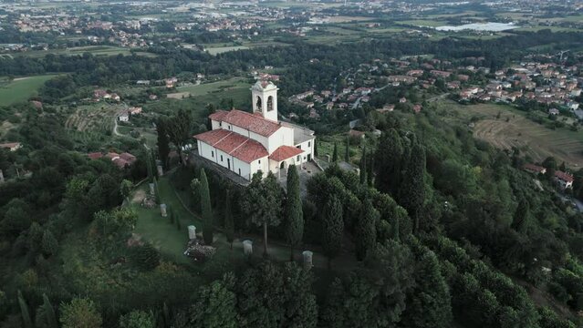 Aerial orbit around cathedral in Montevecchia, Italy named "Santuario della Beata Vergine del Carmelo". Stunning architecture and beautiful forests around. 4K drone shot.