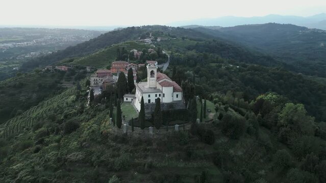 Aerial orbit around cathedral in Montevecchia, Italy named "Santuario della Beata Vergine del Carmelo". Stunning architecture and beautiful forests around. 4K drone shot.