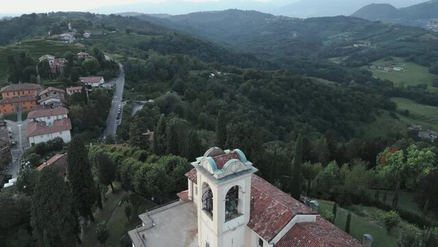 Aerial shot of cathedral in Montevecchia, Italy named "Santuario della Beata Vergine del Carmelo". Stunning architecture and beautiful forests around. 4K drone shot.
